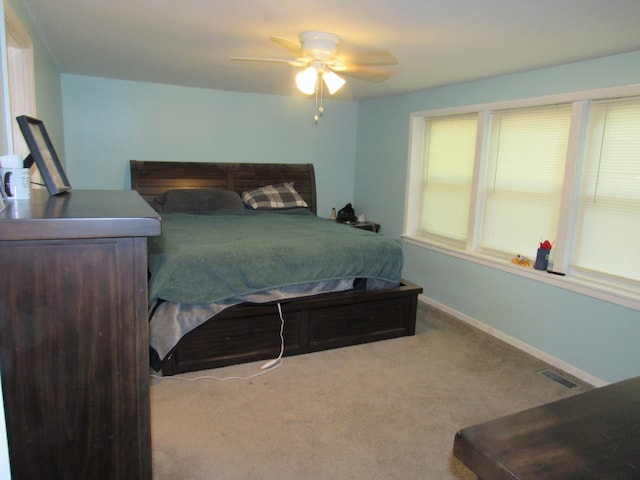 carpeted bedroom with baseboards, visible vents, and ceiling fan