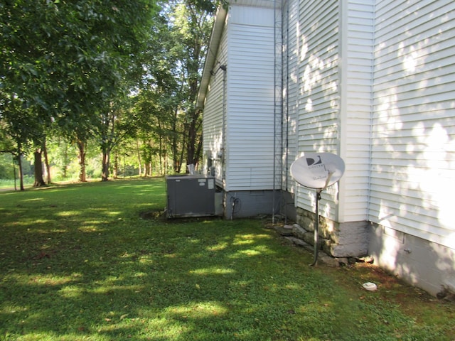 view of property exterior with a lawn, central AC unit, and crawl space