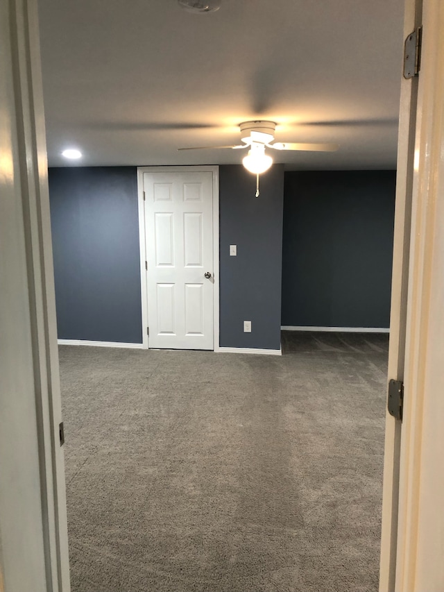 unfurnished bedroom featuring dark colored carpet and ceiling fan