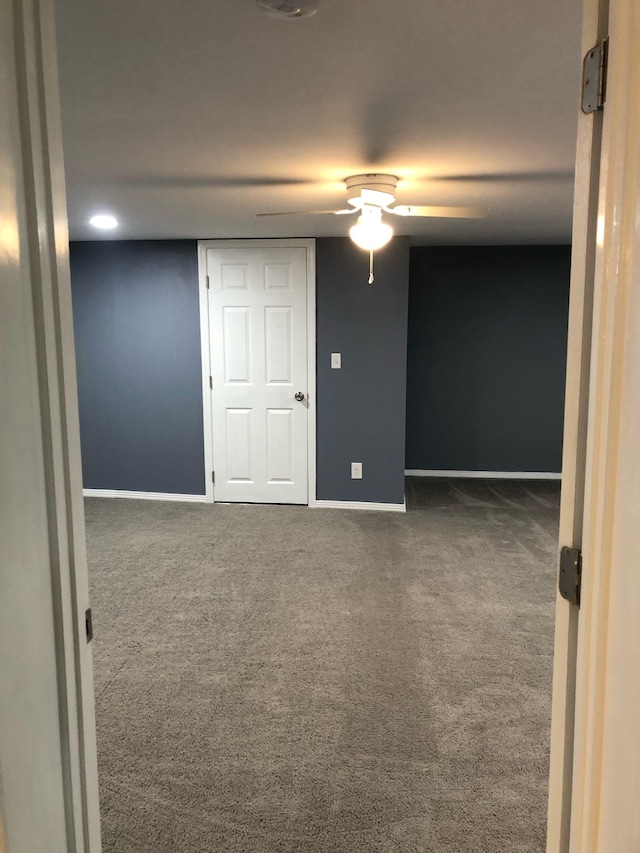 carpeted empty room featuring baseboards and ceiling fan