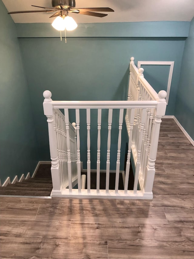 stairway with baseboards, a ceiling fan, and wood finished floors