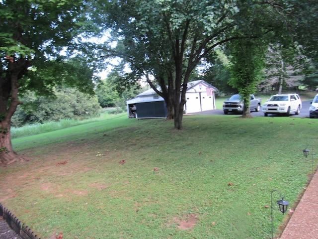 view of yard featuring a garage and an outbuilding