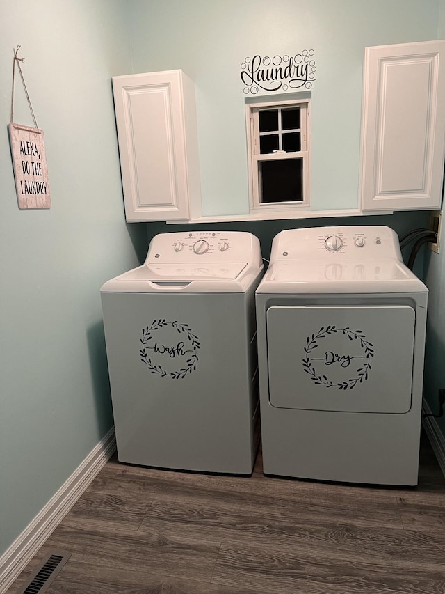washroom featuring visible vents, washing machine and dryer, baseboards, dark wood finished floors, and cabinet space