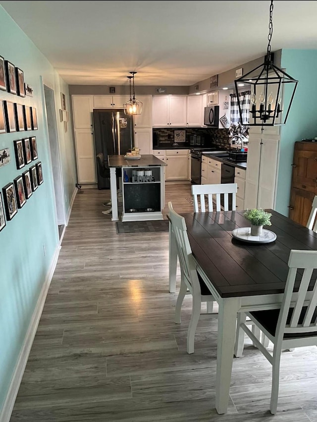 dining space featuring an inviting chandelier, baseboards, and dark wood finished floors