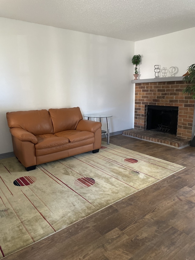 living room featuring hardwood / wood-style flooring, a textured ceiling, and a fireplace