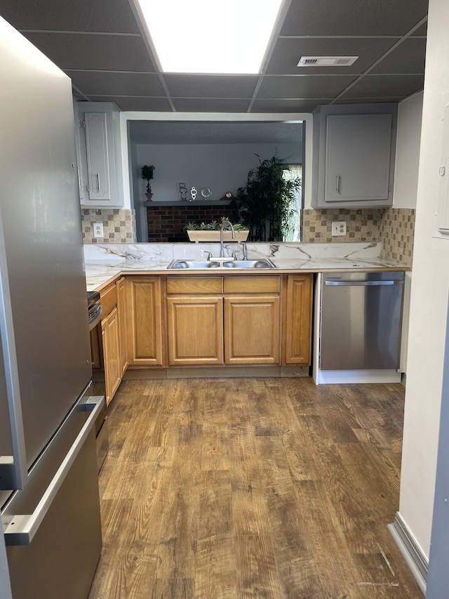 kitchen featuring a drop ceiling, stainless steel appliances, sink, and dark hardwood / wood-style flooring