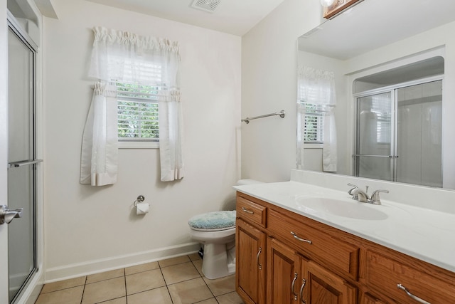 bathroom with vanity, toilet, a shower with shower door, and tile patterned flooring