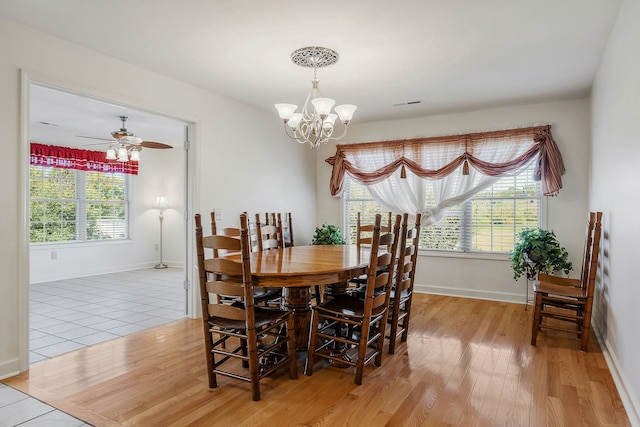 dining room featuring light hardwood / wood-style flooring and ceiling fan with notable chandelier