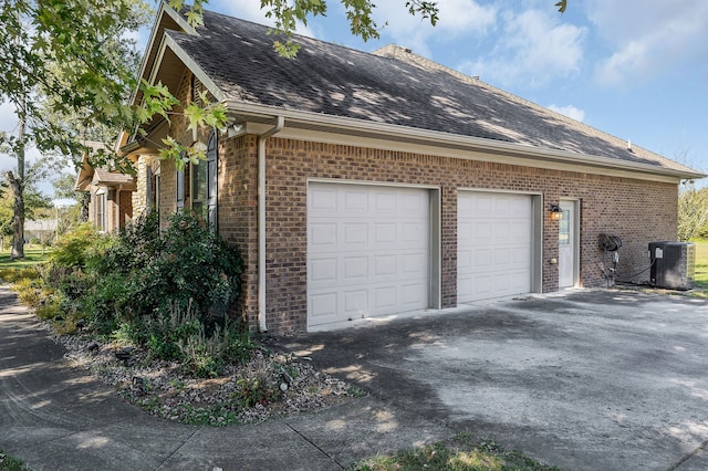 view of side of home featuring a garage and central AC unit