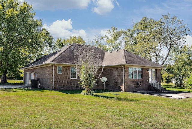 view of side of property with a lawn, cooling unit, and a garage