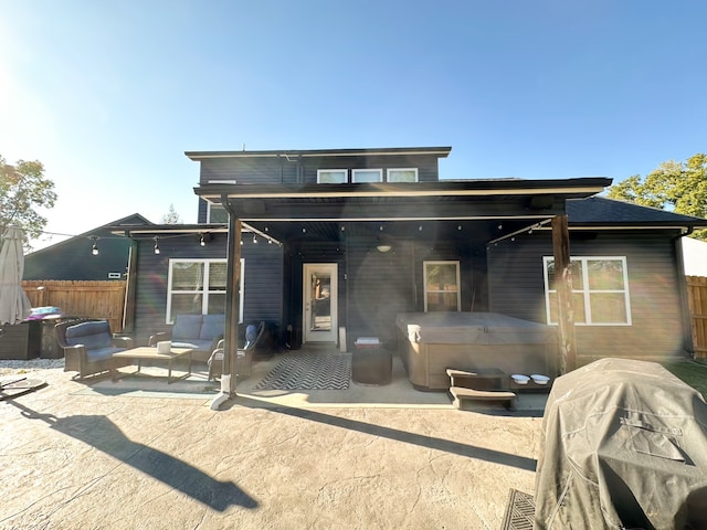 back of house featuring a hot tub and a patio area