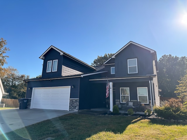 view of front of home with a porch, a front yard, and a garage