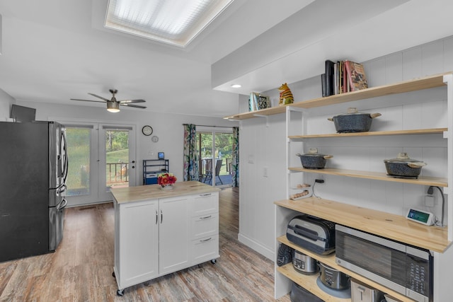 kitchen featuring french doors, light hardwood / wood-style flooring, ceiling fan, white cabinetry, and stainless steel appliances