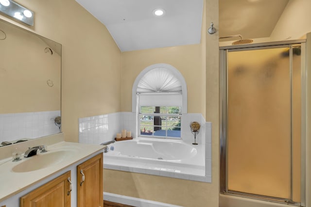 bathroom with vanity, vaulted ceiling, and separate shower and tub