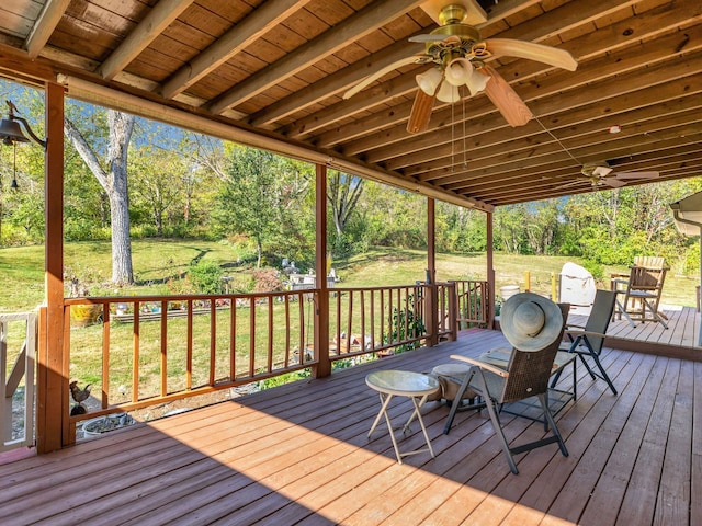 wooden terrace featuring ceiling fan and a lawn