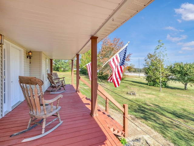 wooden deck with covered porch and a lawn