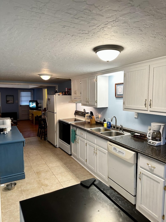 kitchen featuring white appliances, sink, a textured ceiling, light tile patterned flooring, and white cabinetry