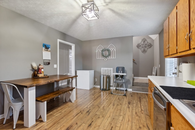 kitchen featuring dishwasher, light hardwood / wood-style flooring, a textured ceiling, and wood counters