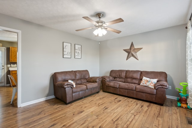 living room with ceiling fan and light wood-type flooring