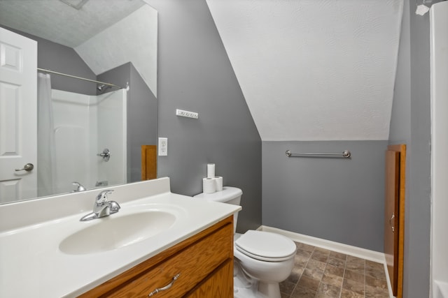 bathroom with a textured ceiling, walk in shower, vaulted ceiling, toilet, and vanity