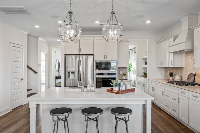 kitchen featuring a center island with sink, stainless steel appliances, and dark hardwood / wood-style floors