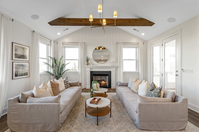 living room featuring lofted ceiling with beams, wood-type flooring, a wealth of natural light, and an inviting chandelier