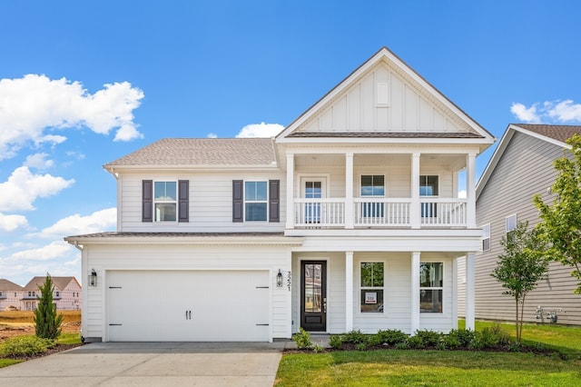 view of front of property with a front yard, a balcony, and a garage