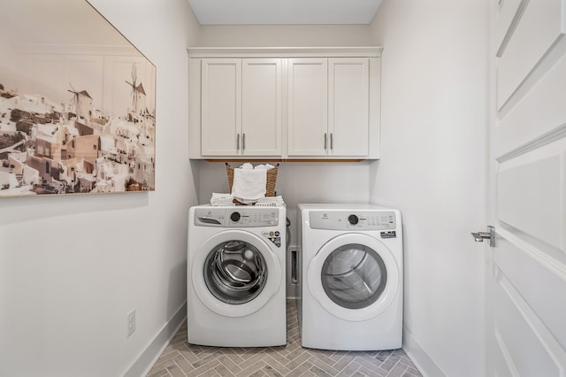 clothes washing area featuring independent washer and dryer and cabinets