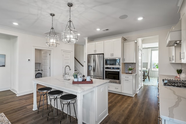 kitchen with white cabinetry, stainless steel appliances, and hanging light fixtures