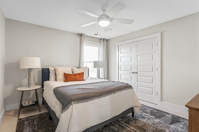 bedroom featuring dark carpet, a closet, and ceiling fan