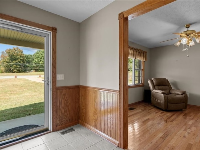 interior space with ceiling fan, a textured ceiling, light hardwood / wood-style floors, and plenty of natural light