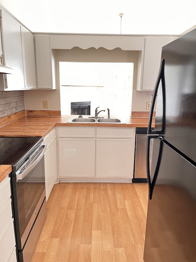 kitchen featuring light hardwood / wood-style flooring, white cabinetry, stainless steel appliances, and sink