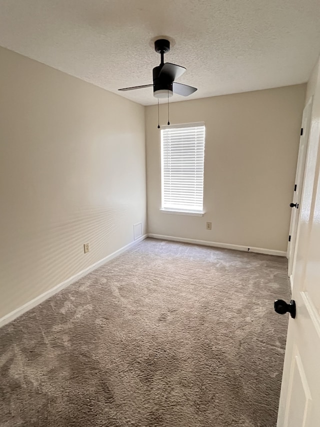 carpeted spare room with a textured ceiling and ceiling fan