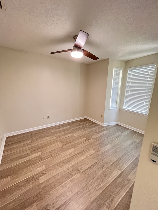 empty room featuring light hardwood / wood-style floors, a textured ceiling, and ceiling fan