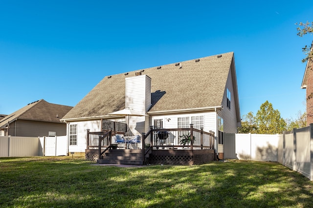 back of house with a deck and a lawn