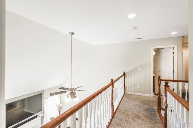 hallway with carpet and vaulted ceiling