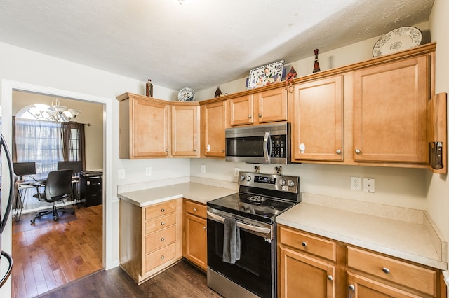 kitchen featuring dark wood-type flooring, a notable chandelier, appliances with stainless steel finishes, and a textured ceiling