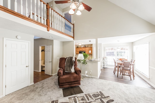 carpeted living room featuring high vaulted ceiling and ceiling fan