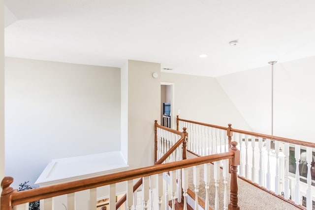 hall with carpet and lofted ceiling