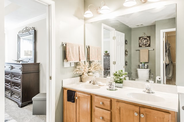 bathroom with toilet, crown molding, and vanity