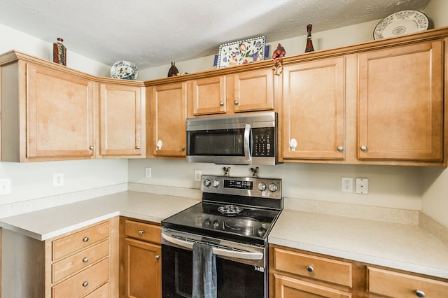 kitchen featuring stainless steel appliances and a textured ceiling