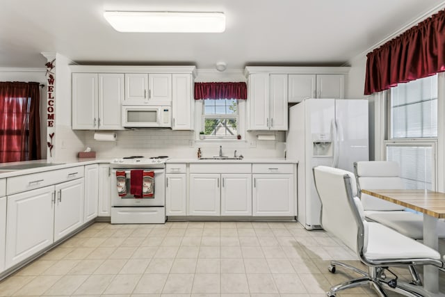 kitchen featuring decorative backsplash, ornamental molding, sink, white cabinetry, and white appliances