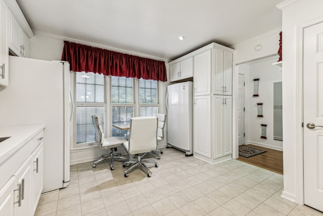 interior space with crown molding, white cabinets, and white refrigerator