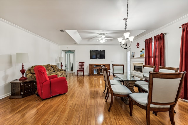 dining space with crown molding, hardwood / wood-style flooring, and ceiling fan with notable chandelier