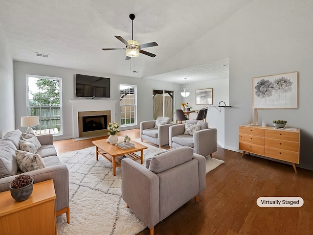 living room with ceiling fan, a textured ceiling, vaulted ceiling, and hardwood / wood-style floors