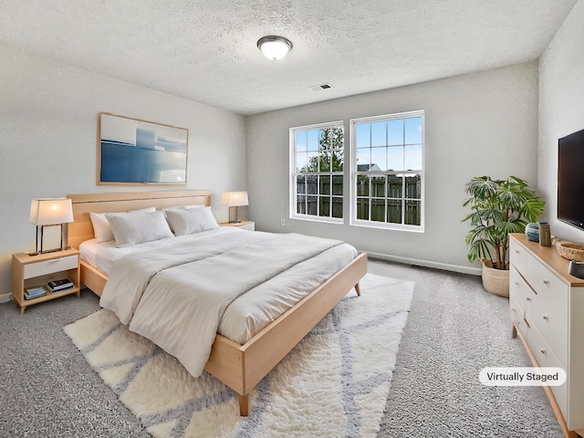 bedroom with carpet and a textured ceiling