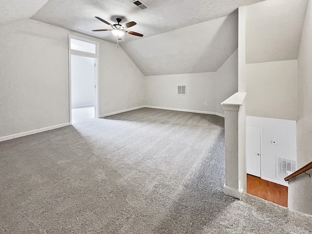 bonus room featuring lofted ceiling, carpet, and a textured ceiling