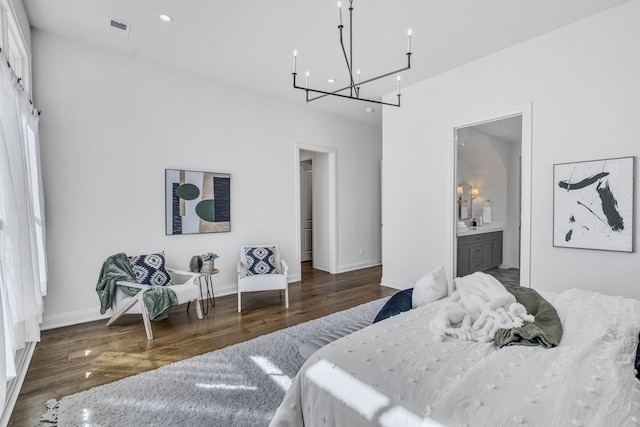 bedroom featuring ensuite bathroom, a chandelier, and dark hardwood / wood-style floors