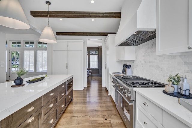 kitchen with beam ceiling, hanging light fixtures, custom range hood, stainless steel appliances, and light hardwood / wood-style floors