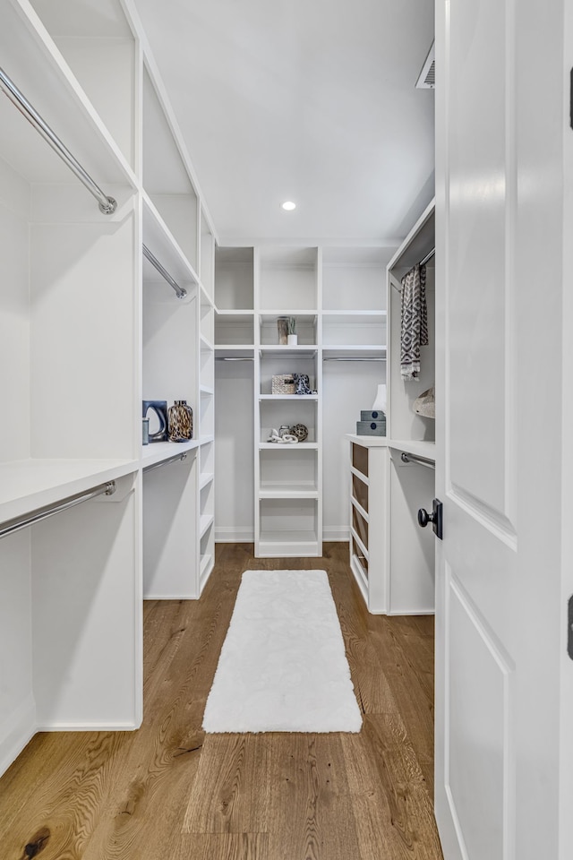 walk in closet with dark hardwood / wood-style floors